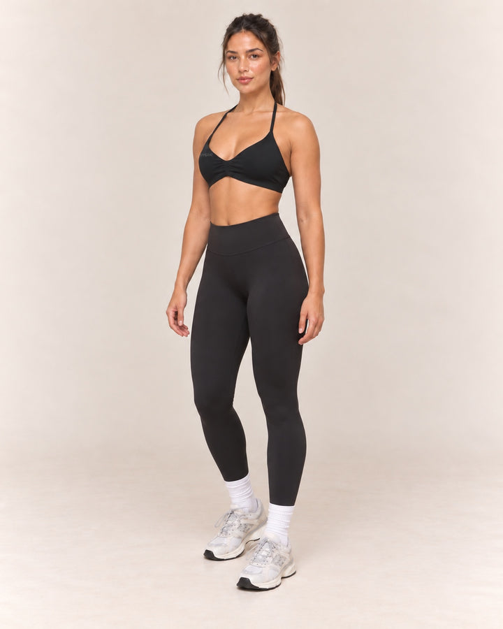 By Shybani Halter Sports Bra in Black — front three-quarter