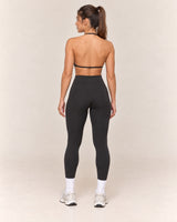 By Shybani Halter Sports Bra in Black — back