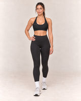 By Shybani Scoop-Neck Halter Bra in Black — front step