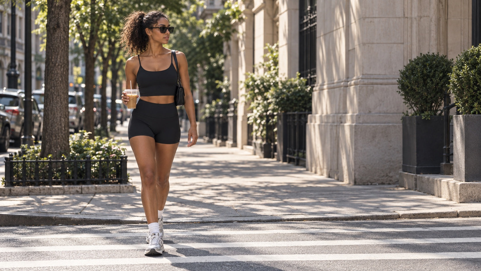 Model draagt de zwarte crop top en studio short tijdens een koffierun